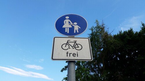 Schild Gehweg Radfahrer frei, vor blaumen Himmel mit Baum