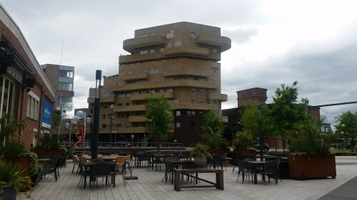 De Eekenhof in Enschede Roombeek vom Architekturbüro Claus & Kaan ausgezeichnet mit dem Fritz Höger-Preis für Backstein-Architektur 2008. Das auch als Zorgcluster bezeichnete Gebäude beherbergt im Erdgeschoss Arztpraxen und Gesundheitseinrichtungen, in den Ebenen darüber Wohnungen für geistig Behinderte.

Der 13. Mai 2000 war ein schwarzer Tag in der niederländischen Stadt Enschede. Mitten im Stadtteil Roombeek explodierte die Feuerwerkfabrik S. E. Fireworks. 177 Tonnen Feuerwerkskörper legten das ganze Stadtquartier in Trümmer.

23 Menschen – darunter vier Feuerwehrmänner – starben, 947 Menschen wurden verletzt. 1.500 Wohngebäude wurden durch die Explosion beschädigt oder gerieten durch umherfliegende Feuerwerkskörper in Brand. 200 Wohnhäuser wurden vollständig zerstört und rund 300 als unbewohnbar erklärt. Darüber hinaus wurden über 100 Betriebe beschädigt. In nur einer Stunde verlieren mehr als 1.250 Einwohner ihr Zuhause.

Etwa zwei Drittel des 65 Hektar großen Stadtviertels, welches nördlich an den Hauptbahnhof und die Innenstadt anschließt, waren durch die Explosion betroffen. Mit der Katastrophe waren jedoch auch Chancen und Entwicklungspotenziale verbunden, welche einen Neuanfang für das durch die sterbende Textilindustrie geprägte Quartier bedeuten.

Der für den Wiederaufbau entwickelte Masterplan von Pi de Bruijn (de Architecten Cie. aus Amsterdam - www.cie.nl/projects/53 | Video: https://vimeo.com/51809482) verkörpert eine State of the Art-Stadtplanung. Die 1350 neu errichteten Wohnungen befinden sich in einem durchmischten Gebiet, welches durch kulturelle Angebote, Geschäfte und soziale Einrichtungen ergänzt wird. Freiräume, Wasser und Grün spielen ebenfalls eine große Rolle.

Dabei hat Pi de Bruijn den Einwohnern große Freiheit gelassen, selbst zu bestimmen, wie ihre Nachbarschaft aussehen soll. Üblicherweise macht die niederländische Stadtplanung vergleichsweise viele Vorgaben und lässt wenige Freiheiten. In Roombeek konnten rund 50 Prozent der Einwohner ihre neuen Wohngebäude vollkommen frei entwerfen, nur für die Bereiche an den Hauptverkehrsachsen wurden strengere Vorgaben gemacht. Das Straßennetz wurde exakt in der Form wieder aufgebaut, in der es vor der Explosion existierte. Dies sollte den ehemaligen Bewohnern ein rasches Ankommen und Einleben ermöglichen. Zudem wurde versucht, die vereinzelten noch stehenden Gebäude, soweit es geht, zu sichern und weiterzuentwickeln.