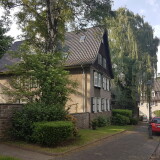 steile-strasse-mit-blick-auf-das-torhaus-in-der-margarethenhohe-in-essen