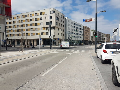 Die Sonnenallee in der Seestadt Aspern mit einem Fahrstreifen für Kfz und einem Radfahrstreifen. Die Haltelinie für Radfahrende ist an der Kreuzung Sonnenallee / Maria-Tusch-Straße leicht nach vorne vor die Kfz-Haltelinie gezogen.