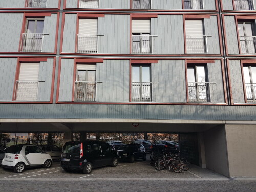 Um den Wohnungsmangel in München zu dämpfen, wurde der weiterhin genutzte öffentliche Parkplatz am Dantebad mit einem Wohngebäude überbaut.

Im Rahmen des Wohnungsbausofortprogramms der Landeshauptstadt München realisierte die städtische Wohnungsbaugesellschaft GEWOFAG das Pilotprojekt im Stadtteil Moosach am Wintereingang des Dantebads entlang der Homerstraße. Auf dem knapp 4.200 m2 großen Grundstück, das sich im Eigentum der Stadt befindet, wurden über dem öffentlichen Parkplatz 100 neue Wohnungen errichtet, davon 86 Einzimmerwohnungen (24 bis 31 Quadratmeter) und 14 Wohnungen mit 2,5 Zimmern (48,8 bis 54 Quadratmeter). Der Quadratmeterpreis liegt bei 9,40 Euro (kalt).

Der Großteil der Parkplätze konnte trotz der Überbauung erhalten werden. Das Grundstück ist gut an öffentliche Verkehrsmittel angebunden.

Der neue Wohnkomplex steht auf einer Betonrahmenkonstruktion mit Stahlbetondecke. Die darüberliegenden vier Stockwerke sind in Holzsystembauweise gefertigt. Die Bauzeit betrug 180 Tage. Inklusive Planung, Ausschreibung, Baugenehmigung sowie Bauphase hat das Projekt etwa ein Jahr gedauert.

Das schwellenfreie Gebäude besitzt insgesamt fünf Geschosse inklusive der Parkplätze, die nach der Fertigstellung zum Großteil wieder genutzt werden können. Es gibt Treppen sowie einen Aufzug. Vier Wohnungen sind rollstuhlgerecht. Bei Bedarf können weitere Wohnungen so umgerüstet werden. Gemeinschaftsräume, Aufweitungen von Laubengängen und Freiflächen auf dem Dach bieten den Mieterinnen und Mietern Möglichkeiten des Aufenthalts außerhalb ihrer Wohnung und zur Begegnung.

Film: https://www.youtube.com/watch?v=TrHFjZ_Zhd8