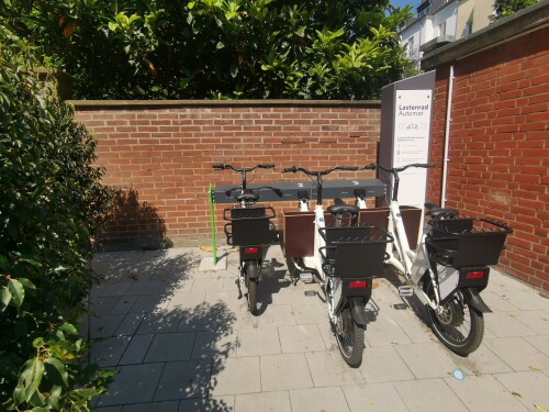 An "LastenradAutomaten" können E-Lastenräder und E-Bikes ausgeliehen werden. Im Bild ist der Standort Karolingerstraße, an dem Lastenräder für die Anwohnerschaft der SWD ausgeliehen werden können. Die städtische Tochter Connected Mobility Düsseldorf ist für den Service und Betrieb der ›LastenradAutomaten‹ zuständig. Technisch basiert der Lastenradautomat auf Sharinglösungen von Velocity Mobility.