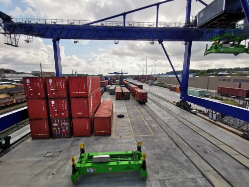 Containerbrücke mit zwei innenliegenden Gleisen am bimodalen Containerterminal (Schiene - Straße) in Hof an der Saale. Im Vordergrund eine abgelegte Katze.